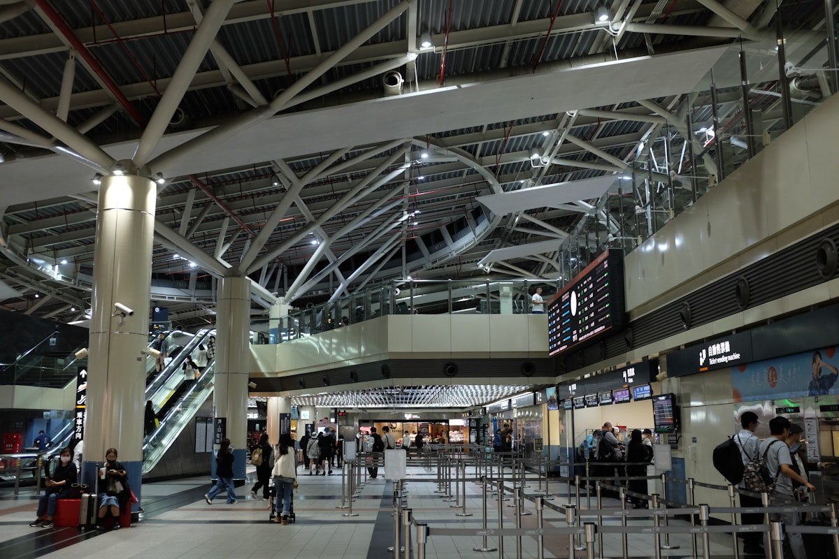 Passengers in a busy airport terminal looking at the departure board